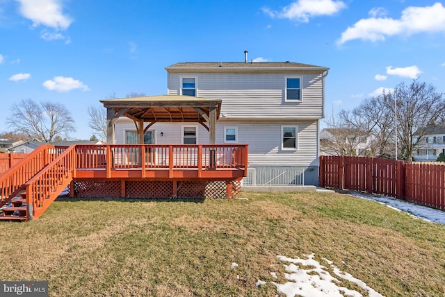 rear view of property featuring a wooden deck, a gazebo, and a lawn