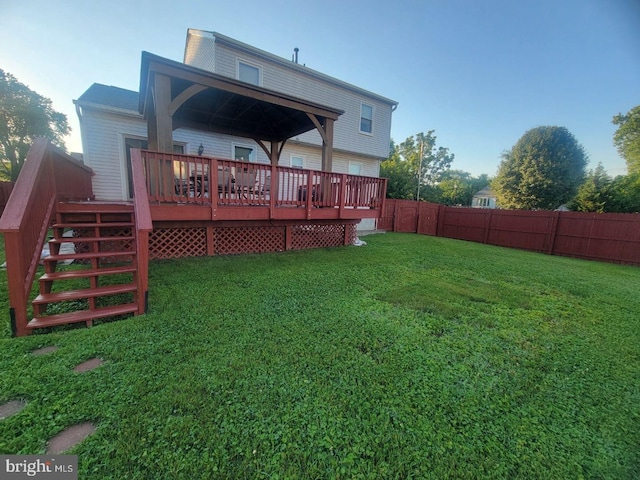 back of property with a yard and a deck