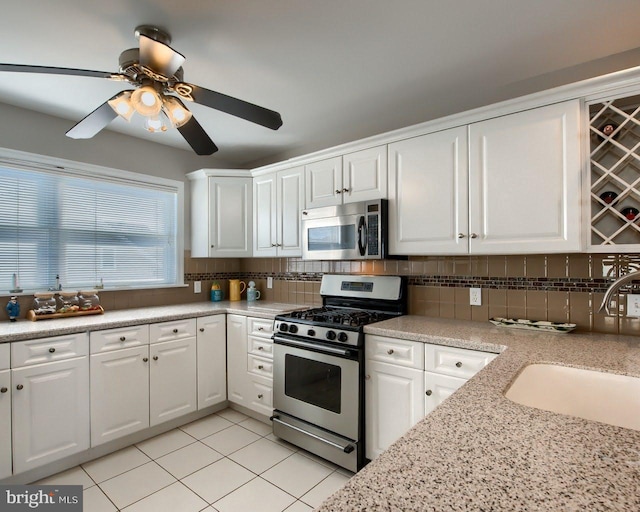 kitchen featuring stainless steel appliances, white cabinetry, tasteful backsplash, and sink