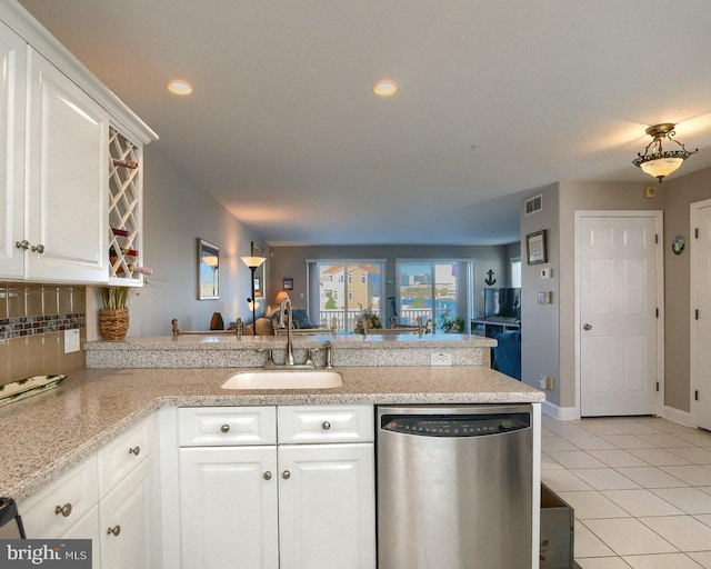 kitchen featuring white cabinetry, dishwasher, sink, kitchen peninsula, and decorative backsplash