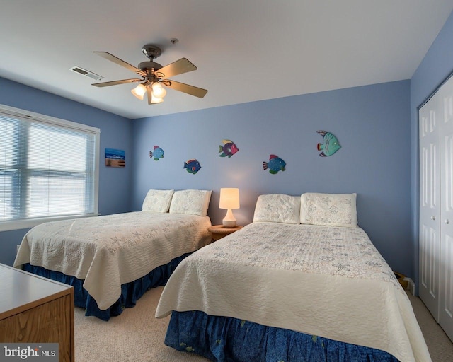 bedroom featuring ceiling fan, light colored carpet, and a closet