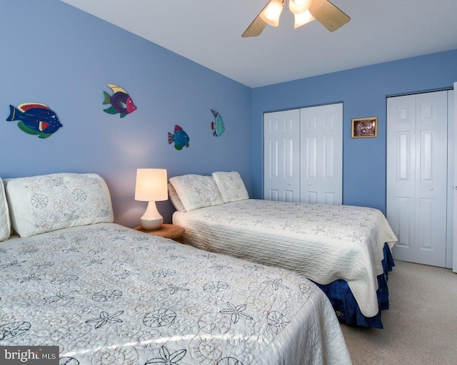 carpeted bedroom with multiple closets and ceiling fan