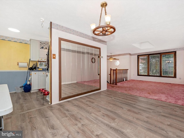 entrance foyer with ceiling fan with notable chandelier and light hardwood / wood-style flooring