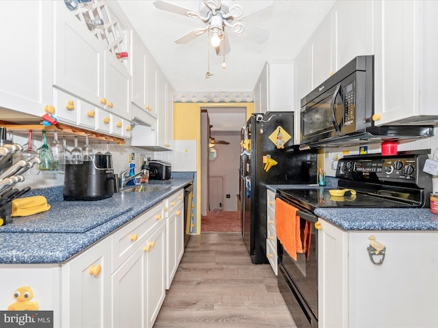 kitchen with decorative backsplash, white cabinetry, light hardwood / wood-style flooring, and black appliances