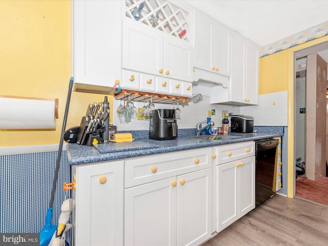 kitchen featuring dishwasher, white cabinets, light hardwood / wood-style floors, and sink