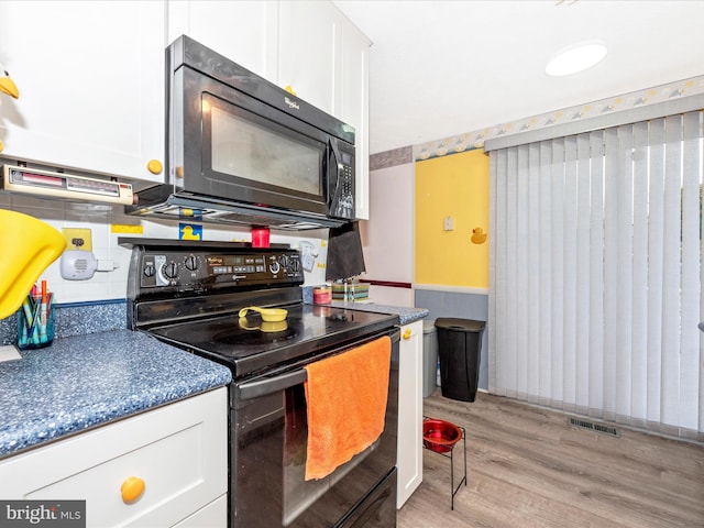 kitchen with black appliances, white cabinetry, and light hardwood / wood-style flooring