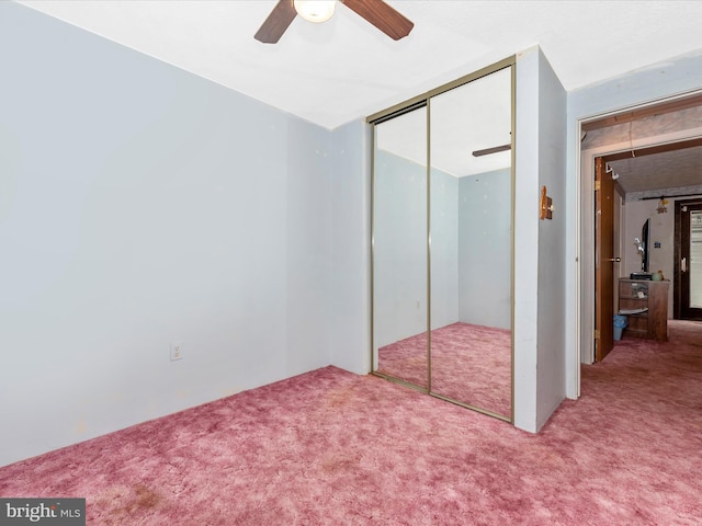 unfurnished bedroom featuring ceiling fan, a closet, and carpet floors