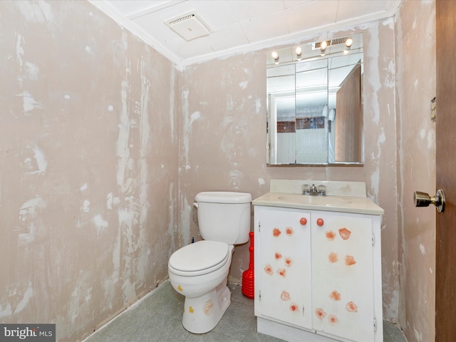 bathroom with toilet, vanity, and ornamental molding