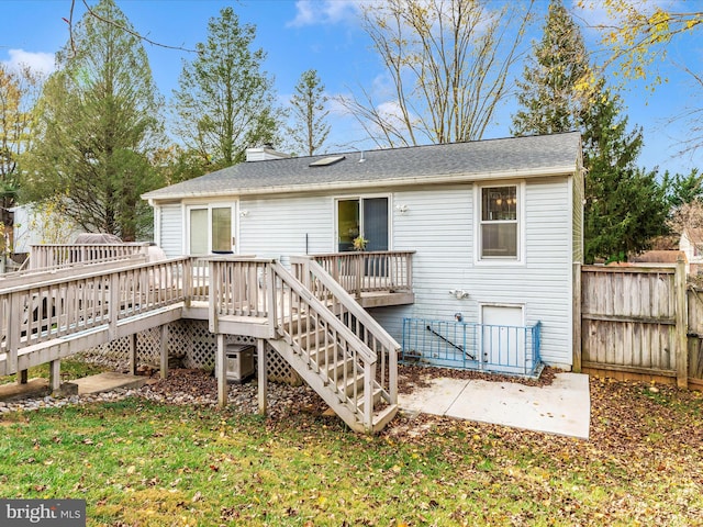 rear view of house featuring a yard and a wooden deck