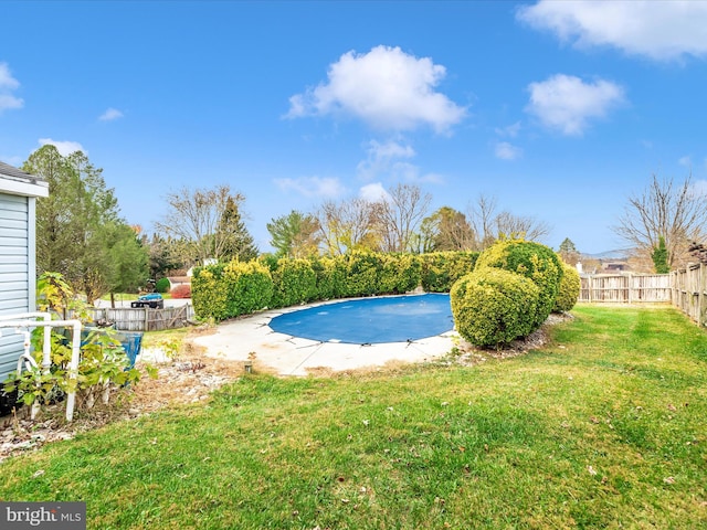 view of swimming pool featuring a yard