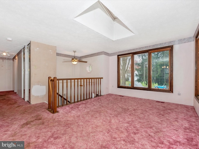 bonus room with a textured ceiling, carpet floors, a skylight, and ceiling fan