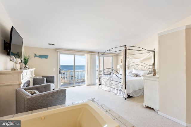 carpeted bedroom with a water view and access to outside