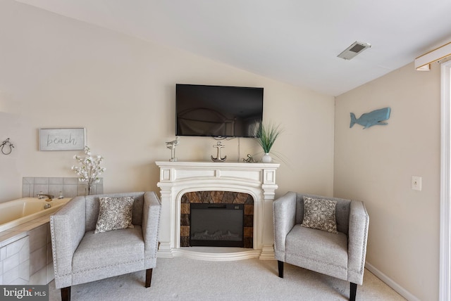 sitting room with lofted ceiling, carpet floors, and a fireplace