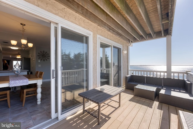 wooden deck with a water view and an outdoor hangout area