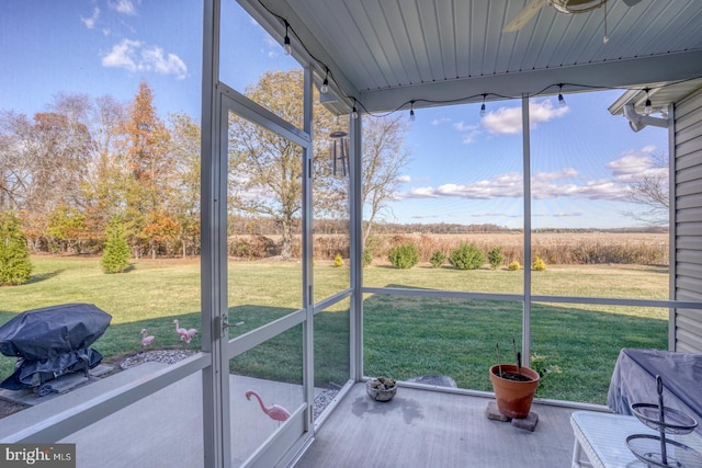 unfurnished sunroom with ceiling fan