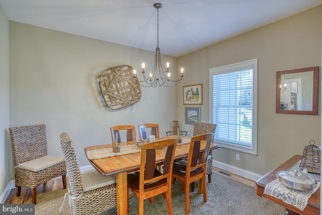 dining room with hardwood / wood-style floors and a notable chandelier