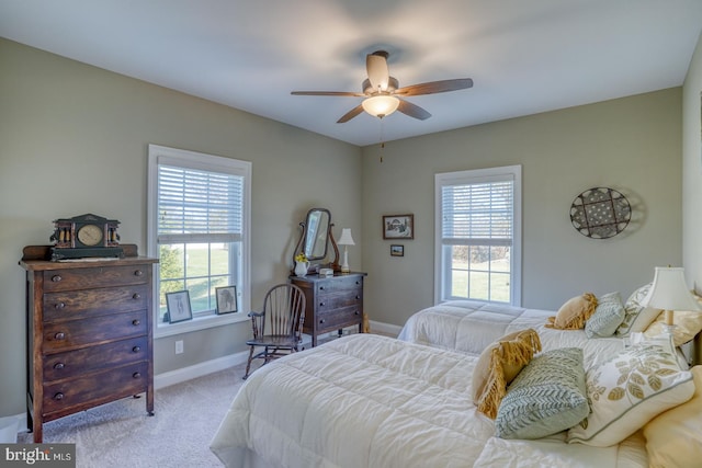 carpeted bedroom featuring ceiling fan and multiple windows