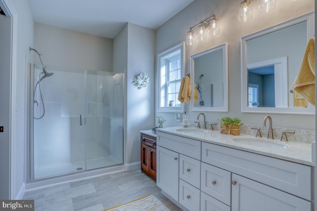 bathroom with a shower with shower door and vanity