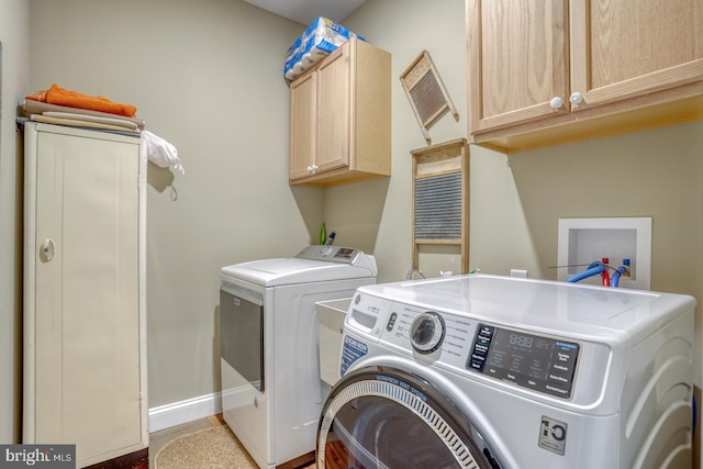 washroom with cabinets and washer and dryer