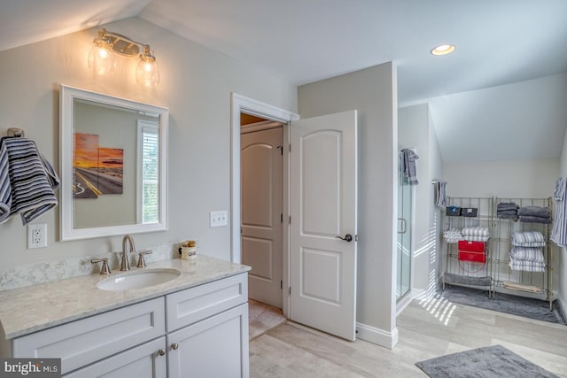 bathroom featuring a shower with door, vanity, vaulted ceiling, and wood-type flooring