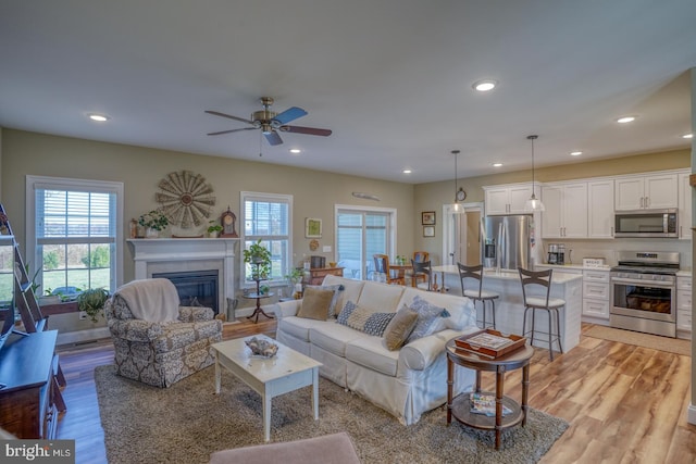 living room featuring light hardwood / wood-style flooring and ceiling fan