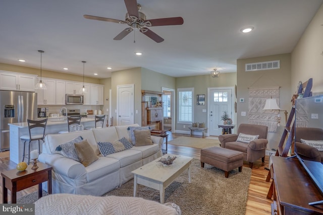 living room with ceiling fan and light hardwood / wood-style floors