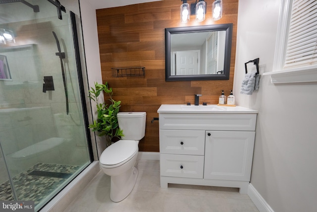 bathroom with toilet, tile patterned flooring, wood walls, vanity, and a shower with shower door