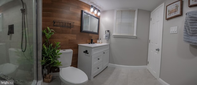 bathroom featuring wood walls, walk in shower, vanity, tile patterned floors, and toilet