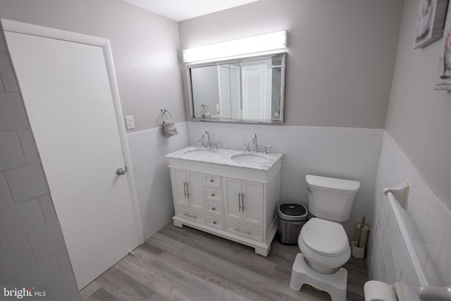 bathroom featuring toilet, vanity, tile walls, and hardwood / wood-style flooring