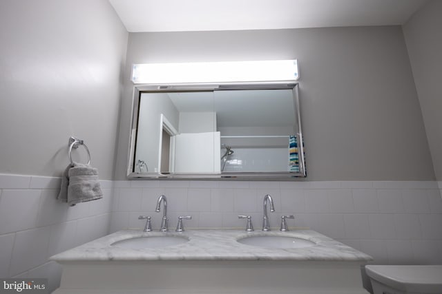 bathroom with tile walls, vanity, and toilet