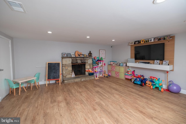 rec room featuring a fireplace and light hardwood / wood-style flooring