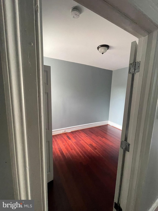 hall featuring beamed ceiling and hardwood / wood-style flooring