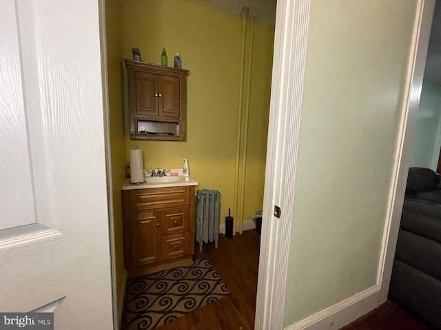 corridor with radiator heating unit and dark hardwood / wood-style floors