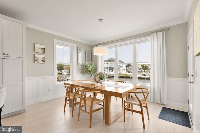 dining room with light hardwood / wood-style flooring, ornamental molding, and plenty of natural light