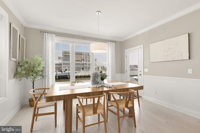 dining space with crown molding and light hardwood / wood-style flooring