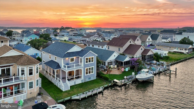 aerial view at dusk featuring a water view