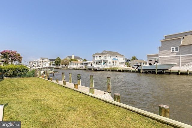 view of dock with a water view and a yard