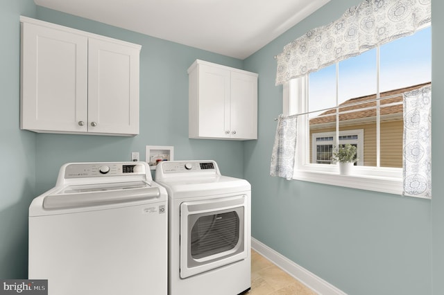 washroom featuring light tile patterned floors, cabinets, and washing machine and clothes dryer