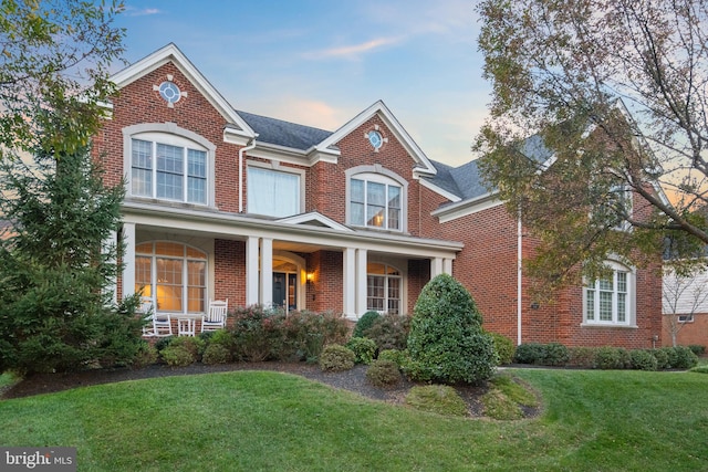 view of front of house with a yard and a porch