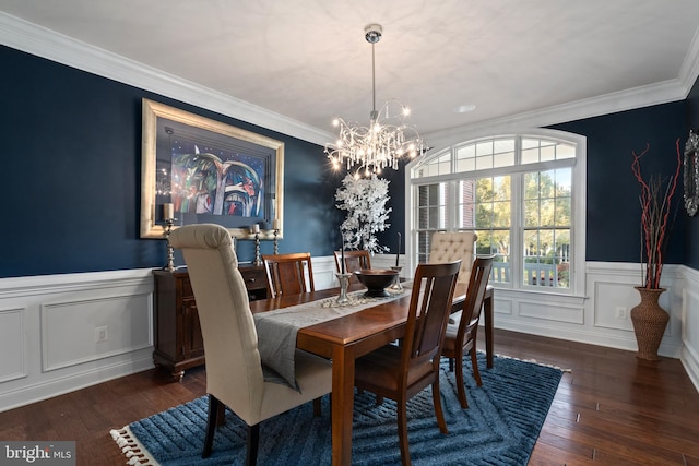 dining space featuring dark hardwood / wood-style floors, an inviting chandelier, and ornamental molding