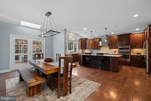 dining area with a skylight, sink, and dark wood-type flooring