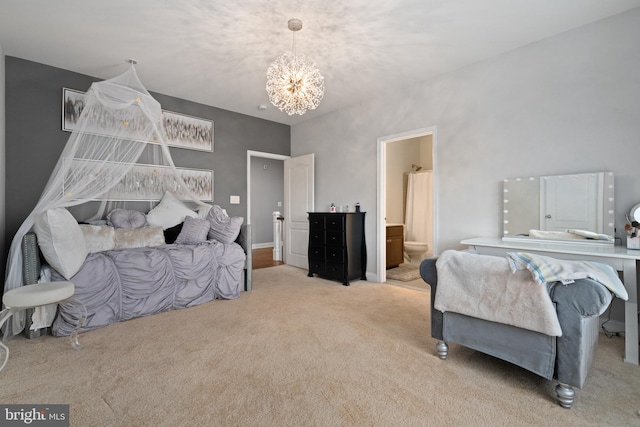 carpeted bedroom with connected bathroom and a notable chandelier