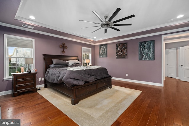 bedroom featuring hardwood / wood-style flooring, ceiling fan, and multiple windows