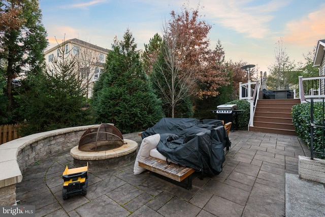 patio terrace at dusk featuring an outdoor fire pit