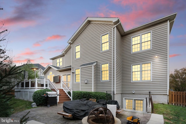 back house at dusk featuring a patio area