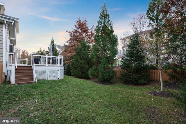 yard at dusk featuring a deck