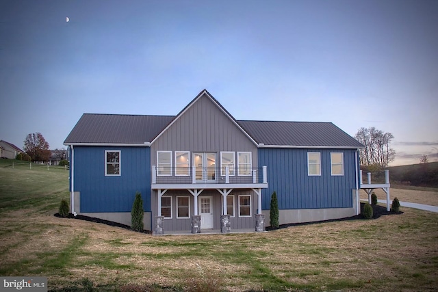 view of front of property featuring a balcony and a lawn