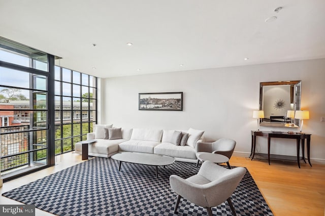 living room featuring light wood-type flooring and floor to ceiling windows