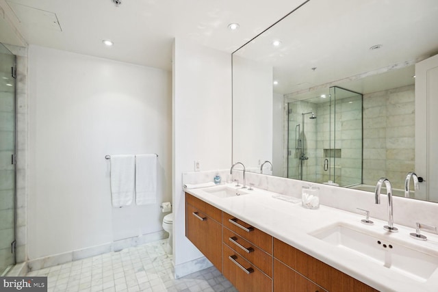 bathroom featuring vanity, toilet, and a shower with shower door