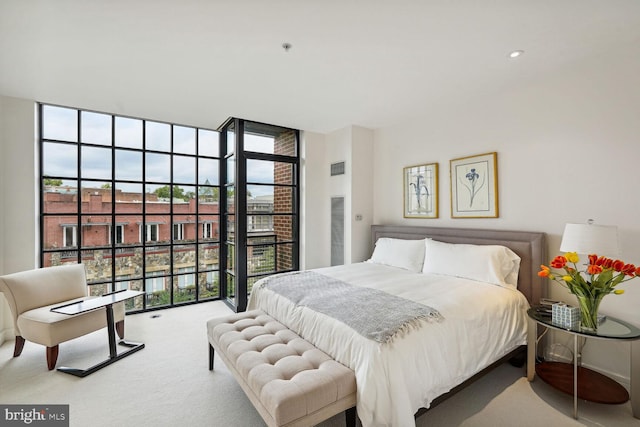 bedroom featuring carpet floors, multiple windows, and floor to ceiling windows